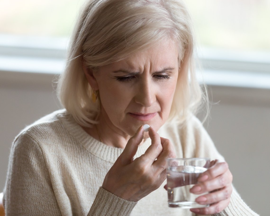 Elder lady taking medication pills